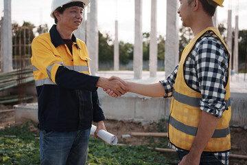 A team of engineers wearing hard hats inspect construction and inspect the site to ensure quality...