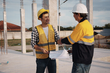 A team of engineers wearing hard hats inspect construction and inspect the site to ensure quality...