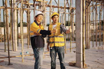 A team of engineers wearing hard hats inspect construction and inspect the site to ensure quality...