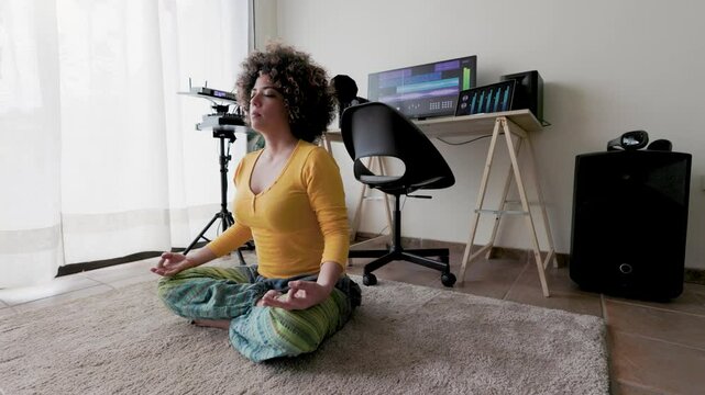 Meditation at work, Hispanic woman doing yoga breathing inside music production studio
