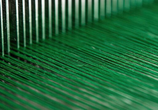 Emerald Threads Intertwine A Close-Up View of Fine Nylon Fibers During the Weaving Process. Intricate Detail