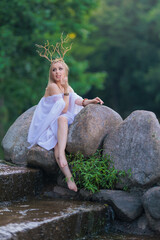 Beautiful girl with long hair and horns in a white dress