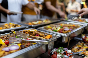 Buffet spread featuring a variety of colorful dishes at a lively social gathering during the evening