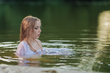 Fototapeta premium Beautiful Girl with long hair sitting in water
