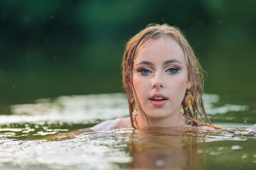 Obraz premium Beautiful Girl with long hair swims and dances in water