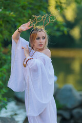 Beautiful girl with long hair and horns in a white dress