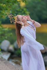 Beautiful girl with long hair and horns in a white dress