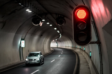Traffic signals illuminate tunnel as vehicle navigates curve