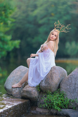 Beautiful girl with long hair and horns in a white dress