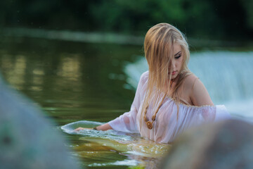 Fototapeta premium Beautiful Girl with long hair swims and dances in water