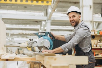 Carpenter cutting wood with circular saw in workshop for modular building