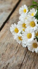 Obraz premium A charming bouquet of freshly cut white daisy flowers with vibrant yellow centers rests delicately on a rustic textured wooden table surface.