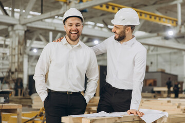 Engineers smiling and discussing plans in modular building factory