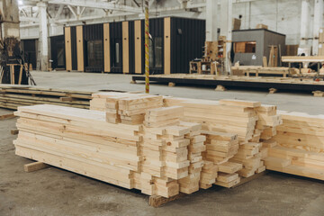 Stacks of lumber sit in modular building factory