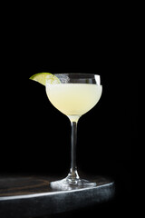 Classic Lime Cocktail – A refreshing citrus cocktail served in a crystal coupe glass, garnished with a slice of lime. Bright, minimalistic, and elegant presentation on a dark marble surface.