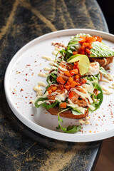 Open Chicken Sandwich with Avocado & Chickpeas – Toasted bread topped with grilled chicken breast, fresh arugula, avocado slices, roasted chickpeas, tomato salsa, and creamy dressing.