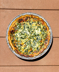 Spinach Quiche pie on a wooden background 