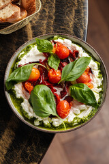 Whipped Feta with Roasted Cherry Tomatoes – Creamy whipped feta cheese topped with roasted cherry tomatoes, fresh basil, and herb oil. Served with artisan bread on the side.
