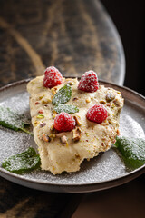 Ricotta Cheesecake with Raspberries & Pistachio.
Light ricotta-based cheesecake slice, topped with fresh raspberries, crushed pistachios, powdered sugar, and mint leaves.
