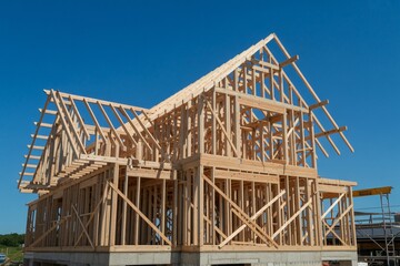 Wooden Frame of a New House Under Construction Against a Blue Sky