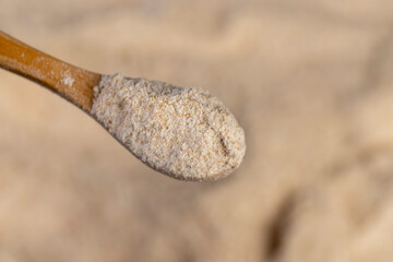 fresh wheat flour close-up, flour for making bread with bran, close up, flour with a wooden spoon