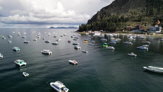 Drone footage of boats and yachts moored on Titikaka Lake's surface in Copacabana, Bolivia