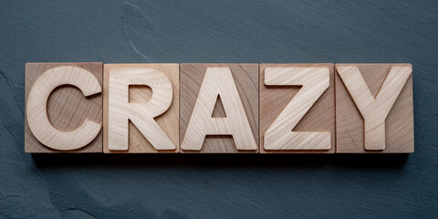 Wooden blocks spelling CRAZY on dark gray background, showcasing a bold and energetic concept