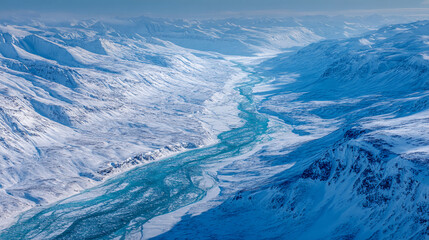 Fototapeta premium Aerial view of a glacial river winding through snow-covered mountains, showcasing a serene winter landscape, representing the power and beauty of nature