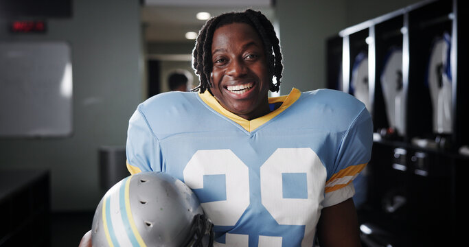 Black man, American football player and excited for portrait in locker room, pride and ready for sports. Person, professional athlete and smile with confidence, career and helmet at club in USA