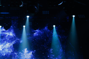 An empty stage of the theater, lit by spotlights and smoke before the performance