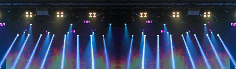 An empty stage of the theater, lit by spotlights and smoke before the performance