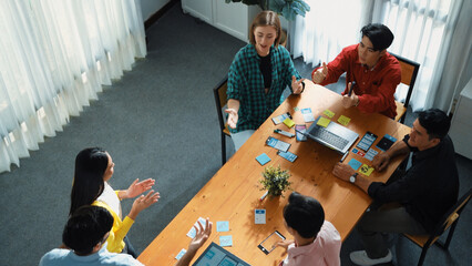 Top view of business team writing sticky notes while manager working on tablet and looking at analysis data. Group of diverse people sharing or exchanging marketing plan. Creative work. Convocation.