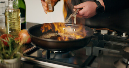 Cooking, flame and man with hands, frying pan and flambe expert with food, dinner and ingredients. Closeup, person and chef with utensils, home and meal prep with nutrition, culinary skills or heat