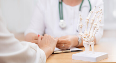 Doctor rheumatologist diagnostics arthrosis of hands of patient. Banner Medical consultation with client in clinic