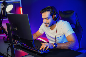 Smart gaming streamer talking with team member players using headset and mic for communicate with others on streaming live on social media application at digital neon lighting studio room. Surmise.