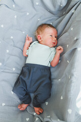 A charming and delightful newborn is peacefully resting on a soft, cozy blanket adorned with lovely...