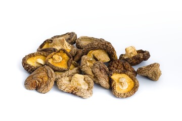 Dried shiitake mushrooms on a white surface, captured with precision to highlight their natural, earthy details.