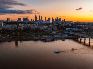 Naklejka premium Warsaw city center and skyscrapers in the background Vistula river and Swietokrzyski bridge. Sunset Warsaw aerial view.