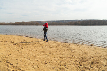 Dad and daughter walking near lake share on sunny day