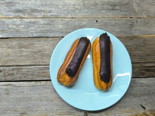 Delicious eclairs on a plate close-up with chocolate