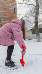 Little girl playing in the park on beautiful winter snow day