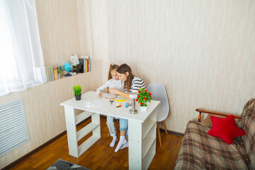 Mother and daughter doing embroidery work. Using embroidery hoop and sewing kit.