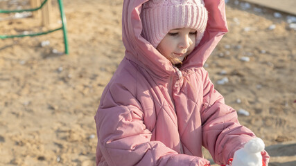  little girl playing on the playground on a winter day