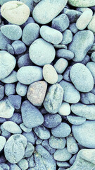 A visually appealing arrangement of blue pebbles, showcasing their smooth surfaces and varying...