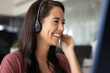 Remote communication. Close up smiling young female in headset speak in portable microphone looking on pc screen. Customer service technical support virtual client consultation online meeting concept