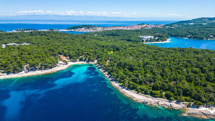 Aerial view of Camping Čikat on Lošinj (Losinj) island, surrounded by a beautiful pine forest and the Adriatic Sea. Known for XTERRA races, biking trails, and crystal-clear coastline views © Viktor