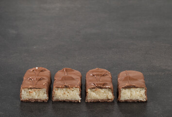 Vegan Chocolate Candy bar with coconut pulp. Dark background. Copy space
