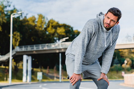 Taking a moment to catch my breath. Cropped shot of an attractive young Caucasian man male runner taking a moment break to rest after his morning run outdoors. Wellness healthy lifestyle copy space