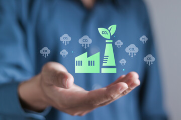 Person holding icon of factory with chimney polluting CO2 cloud smoke. Increasing environmental pollution, emission of Carbon dioxide and energy industry.