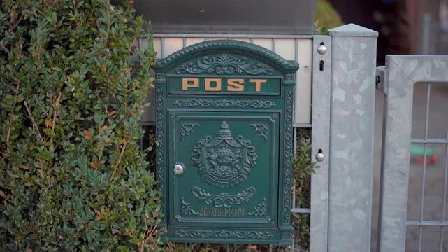 Mailbox outside private house in autumn in Germany, Bavaria city of Munich. Briefkasten in Bayern, Deutschland. Antique postkasten in Munchen. Letterbox in Muenchen. Vintage postbox in private home. 